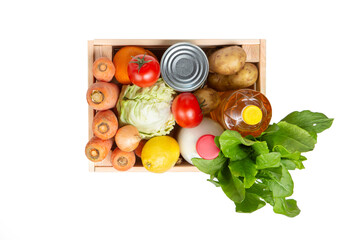 Wooden box with vegetables on a white background. Agricultural products. Delivery of products. Carrots, potatoes, cabbage, tomatoes, canned food, vegetable oil and milk. Flat lay. Fresh vegetables.