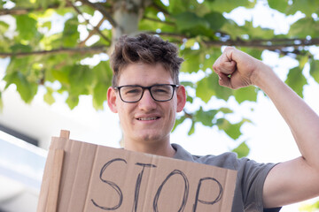 Junger Mann, Akitivist,  auf einer friedlichen Demonstration mit Schild