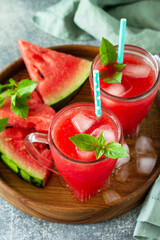 Cold Watermelon Smoothie. Summer Watermelon drink and slices of watermelon on a light stone table.