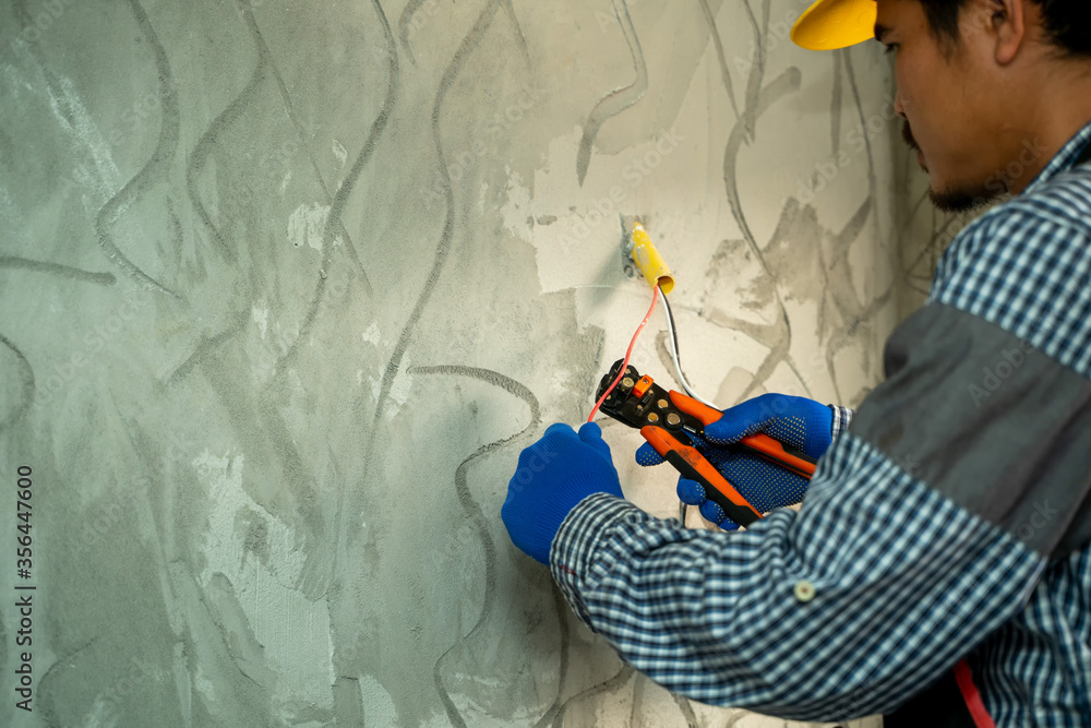 Poster electricians use wire cutting equipment,electrician cuts off part of the power cable when installing