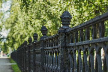 Beautiful wrought iron fence in an industrial city in Russia. Walking along the street on a sunny summer day, tourist notes.