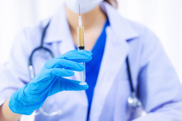 Doctor holding medical injection syringe in hospital.