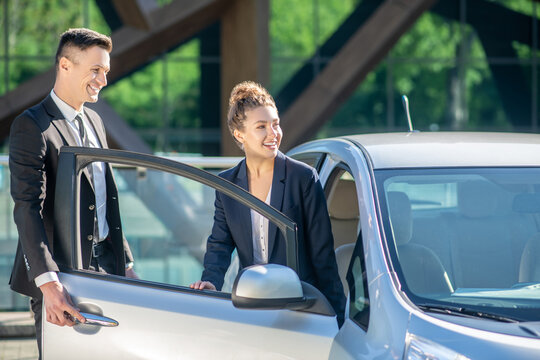 Joyful Woman And Successful Man Near The Open Car Door.