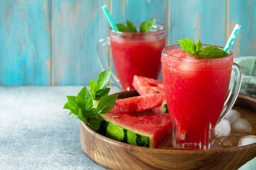 Cold Watermelon Smoothie. Summer Watermelon drink and slices of watermelon on a light stone table. Copy space.