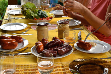 Family dinner at the cottage with toasted sausage and vegetables and mustard