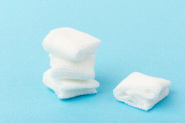 White gauze pads on  blue background. Materials for dental surgery. Close up