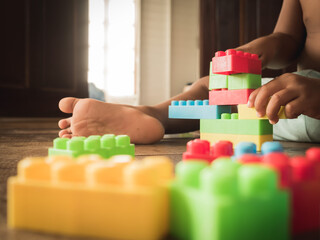 Dark-skinned Asian children are playing blocks at the wooden floor. Learning and development of children