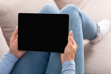 Video call and smart technology. Woman holds tablet In hands sitting on sofa