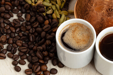 Cup of coffee with roasted beans, seeds and cinnamon