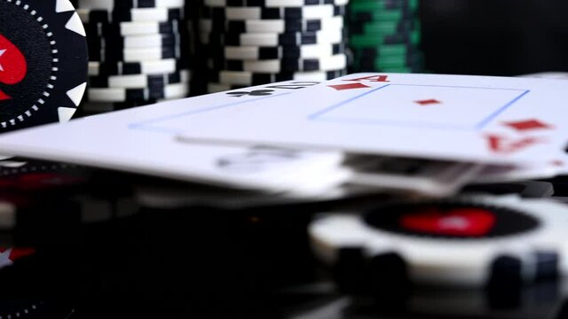 Close Up Of Deck Of Cards Dealt Into Two Piles With Stockpile Of Poker Chips. 