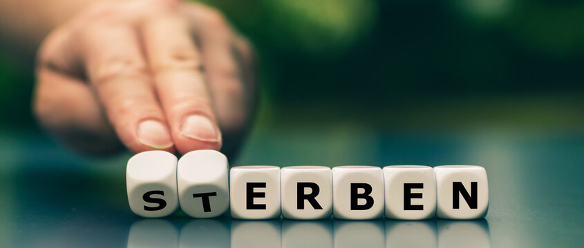 Hand dreht W&uuml;rfel und &auml;ndert das Wort "Sterben" in "Erben".
