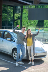 Happy cheerful man and woman near car outdoors
