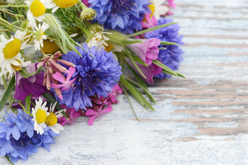 bunch of flowers from meadow flowers with cornflowers on wooden table