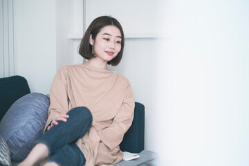 Fototapeta premium ステイホーム・ソファでリラックスする女性