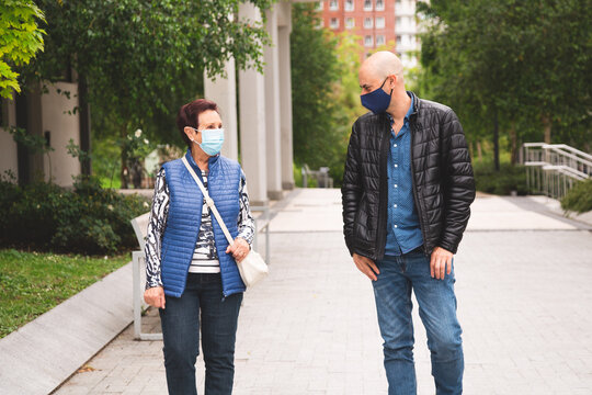 Old Woman Walking With Her Son Wearing Face Mask And Keeping Social Distance