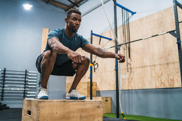 Athletic man doing box jump exercise.