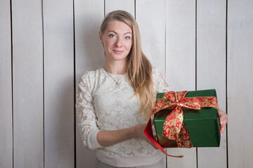 closeup young blond woman shows at camera green gift box holding in hands