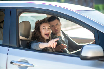 Young couple sitting in the car and looking at something