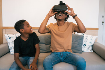 Father and son playing with VR glasses.