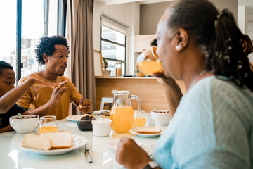 Family having breakfast together at home.