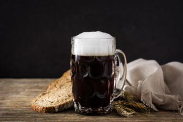 Traditional kvass beer mug with rye bread on wooden table - obrazy, fototapety, plakaty