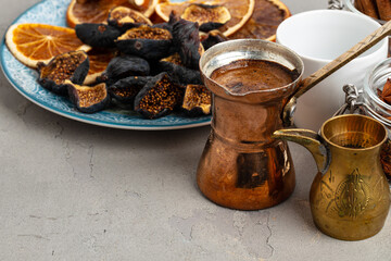 Copper turk with coffee and dried fruit pieces on table