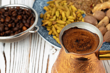 Coffee in metal turk with spices in a plate