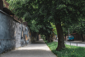 alley in the old town, high brick fence and cobblestones