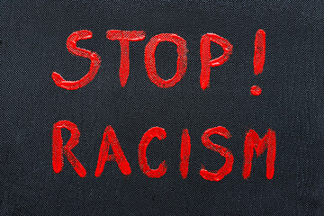 Text stop racism on black background.
