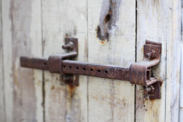 
Old rusty padlock on a wooden door with ragged paint