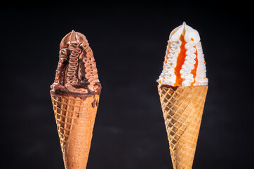 Two frozen ice cream flavors in sugar cones