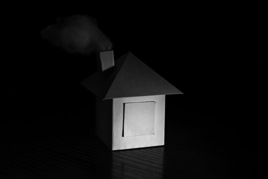 Close Up Of Paper House With Smoke Over Stovepipe. House Concept.