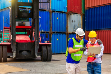 Foreman is controlling air or sea freight. An employee holding a laptop in front of the container.