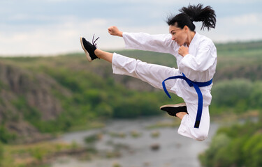 Young female kickboxer training outdoors