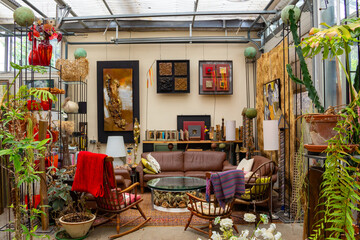Living room in a greenhouse behind a garage door, interior living room with artwork and plants