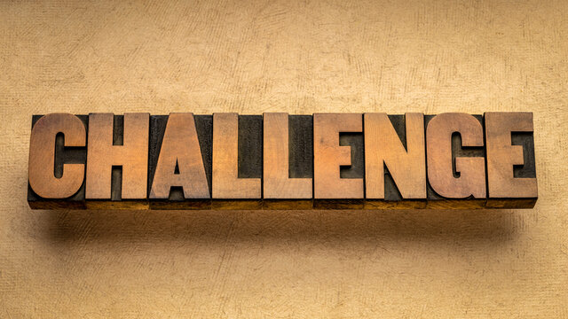 challenge word abstract in vintage letterpress wood type against textured handmade paper