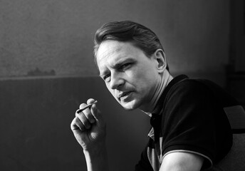 A man with a cigarette. Hard contrast of sunlight. Smoking and health.