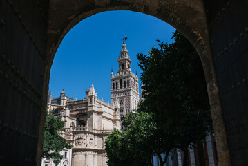 Cathedral of Seville on a sunny day under the arch of the orange tree courtyard. Horizontal photography