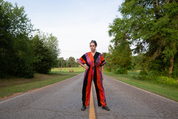 woman in colorful jumpsuit standing in road