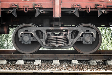Fototapeta na wymiar Closeup of wheelset springs at the railway multiple unit. Unpowered railway vehicles that are used for the transportation of cargo.