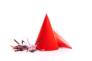 Red birthday hats and noise-makers on a white background.