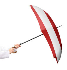 Person wehrt sich mit einem Regenschirm in den Händen und der Flagge von Land. Die...