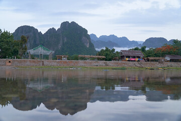 Exterior View of Namsong River and the Limestone Mountainous in Vang Vieng District, Laos. The Mountain reflects on the Namsong River.