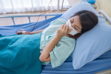 Asian woman is sick has a high fever, sneezing, is recuperating in the patient's dress lay on the...