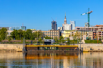 Fototapeta na wymiar Panoramic view of Srodmiescie city center quarter and Powisle district at Wybrzeze Kosciuszkowskie embankment over Vistula river in Warsaw, Poland
