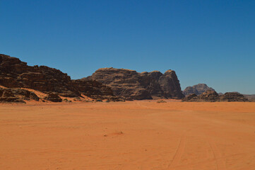 Fototapeta na wymiar Rock formations and red sand at the Wadi Rum Desert, Jordan