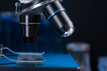 Microscope with lenses close up against dark background