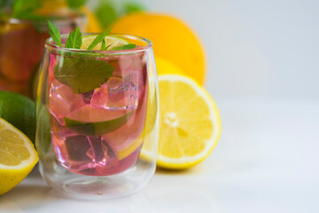 Raspberry juice with lemon and lime slices garnished with mint leaves,