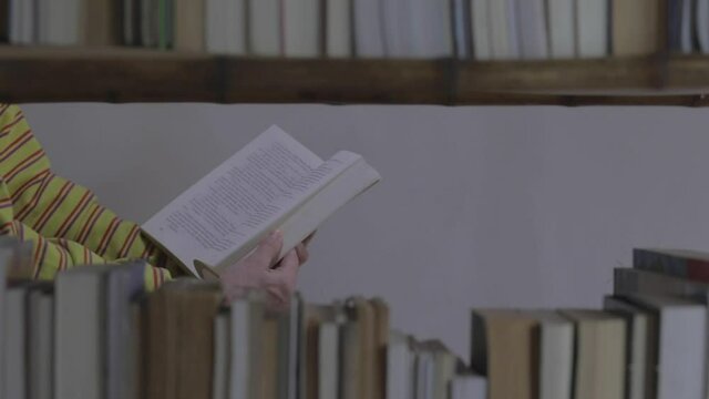 Manos pasan las hojas de un libro en una biblioteca de casa