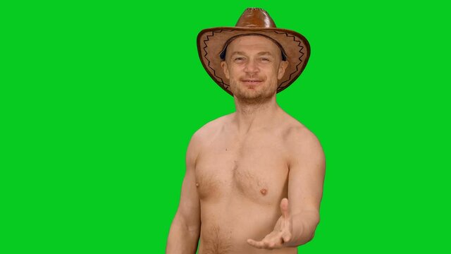 Charming cheerful man in cowboy hat blowing a kiss on green screen background, Сhroma key 